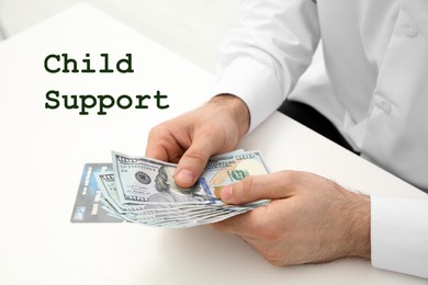 Image of Child support concept. Man with money at white table indoors, closeup