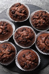 Photo of Tasty chocolate muffins on grey textured table, top view