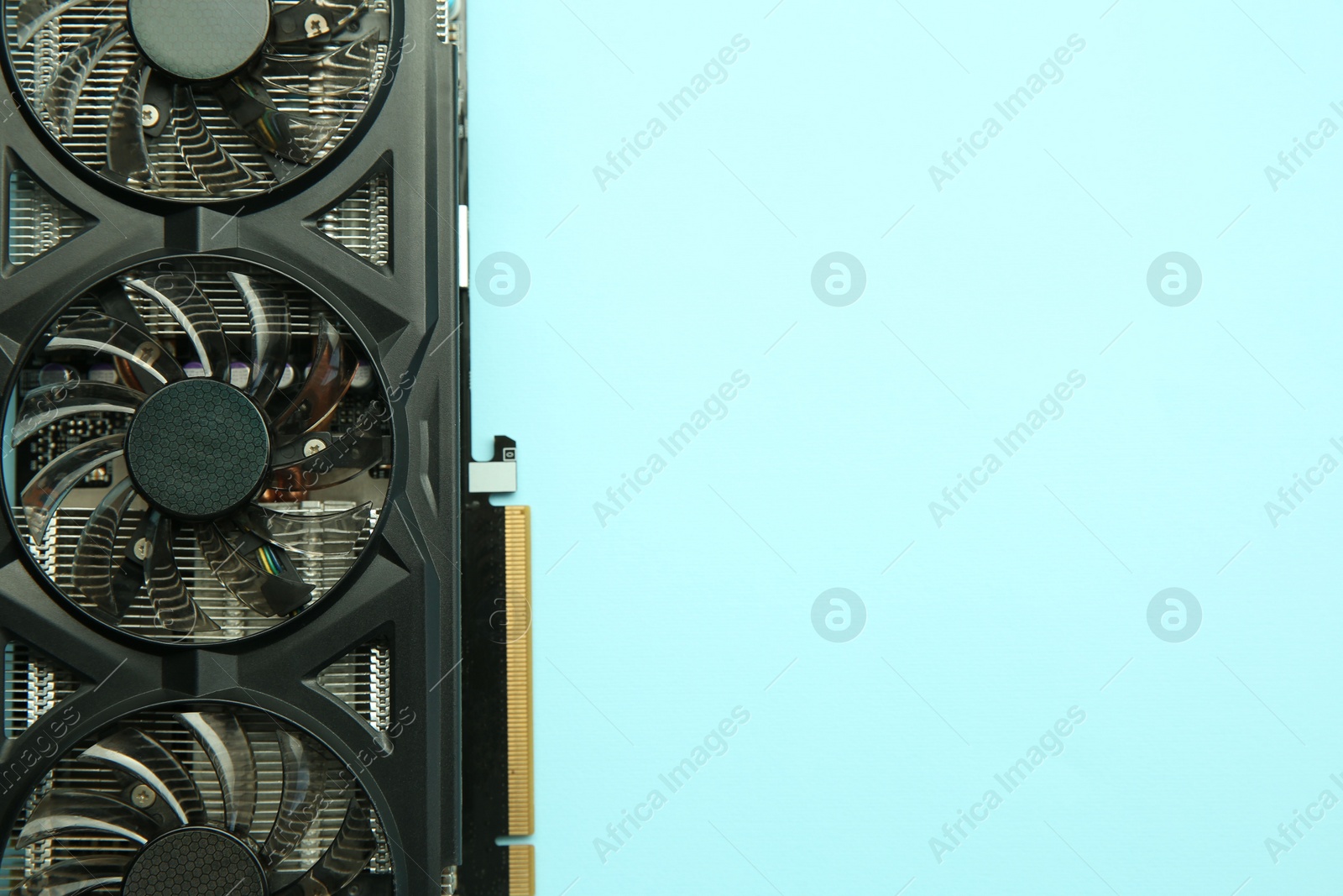 Photo of One graphics card on light blue background, top view. Space for text