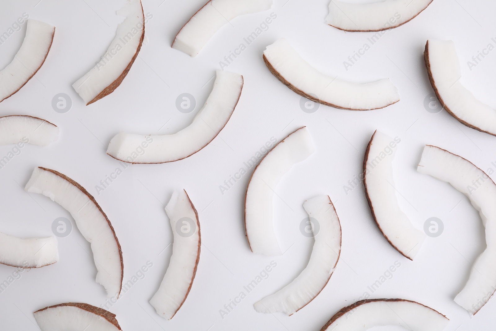 Photo of Pieces of fresh coconut on white background, top view