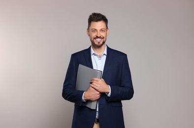 Happy teacher with stationery against beige background