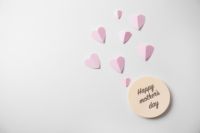 Photo of Greeting card with text HAPPY MOTHER'S DAY and paper hearts on light background