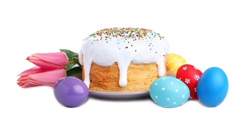 Photo of Traditional Easter cake, tulips and dyed eggs on white background