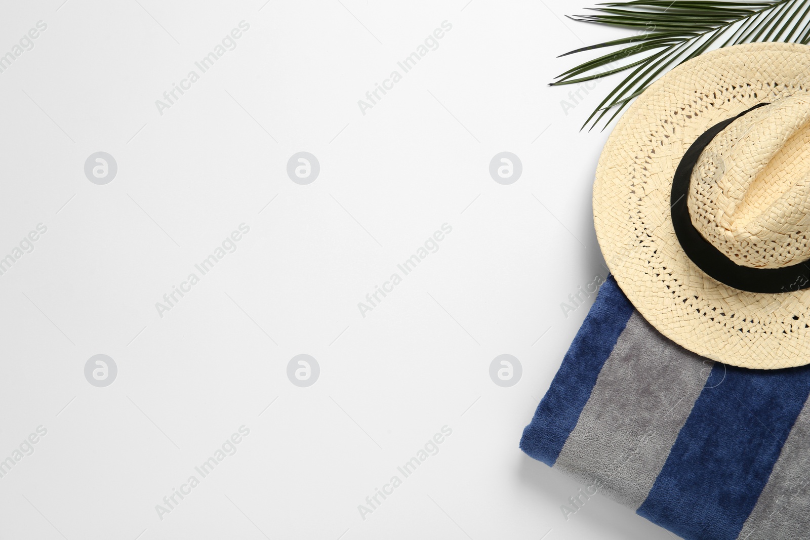 Photo of Beach towel and straw hat on white background, top view