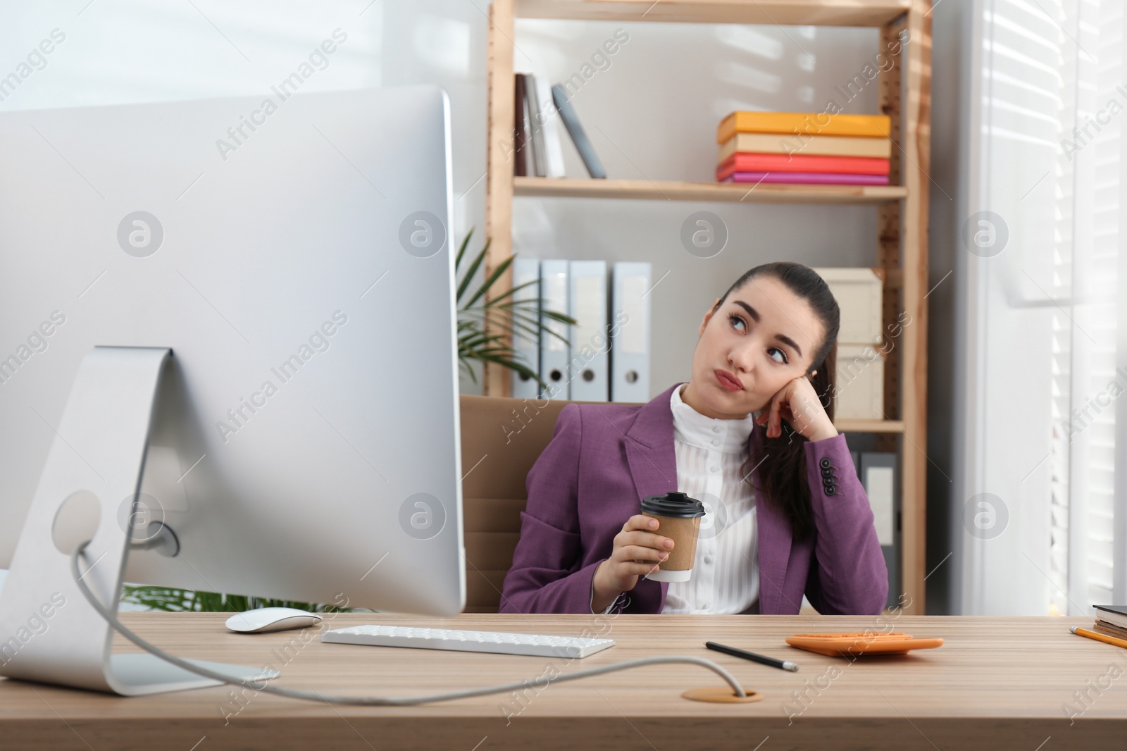 Photo of Lazy employee drinking coffee at table in office