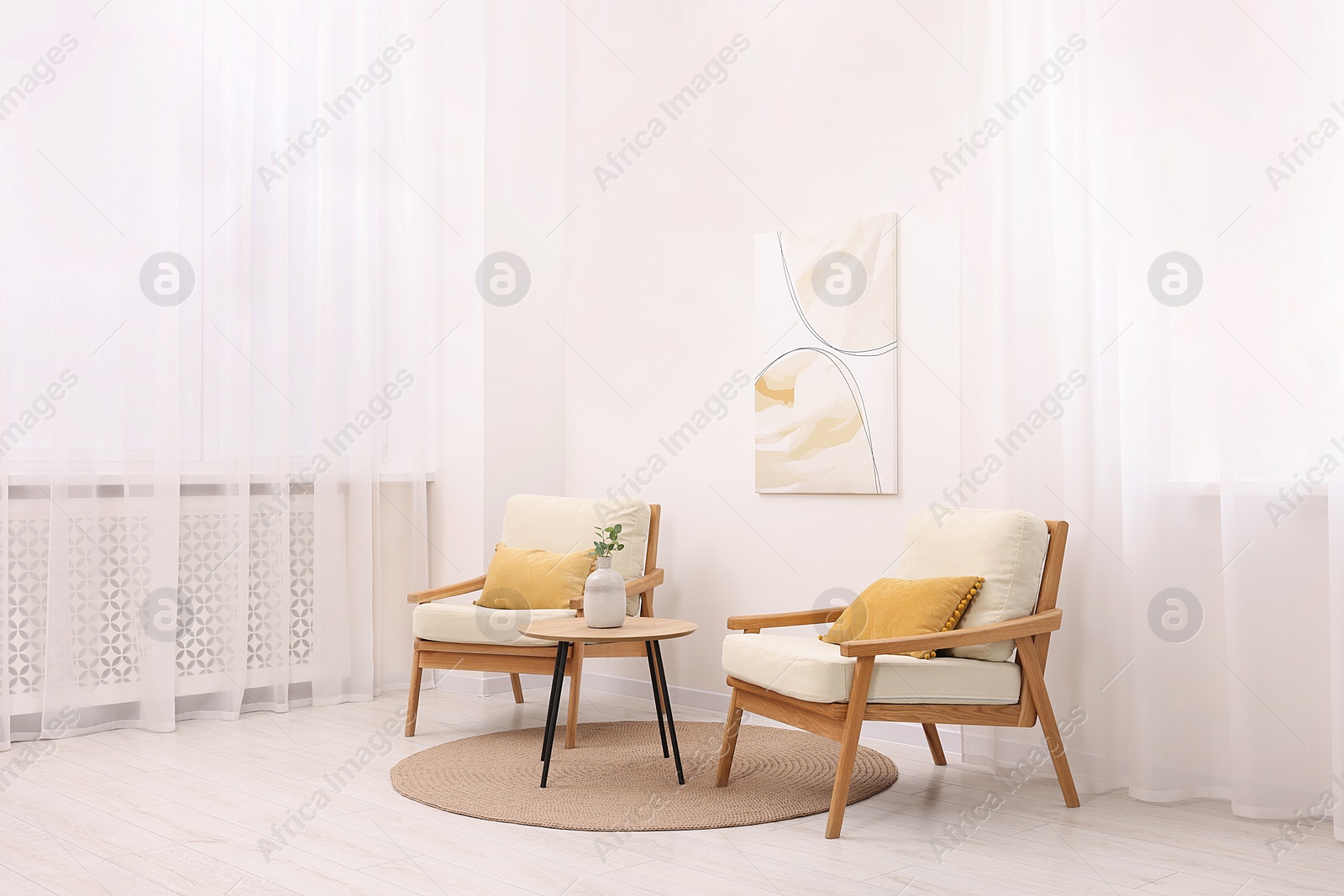 Photo of Stylish armchairs and wooden table in living room. Interior design