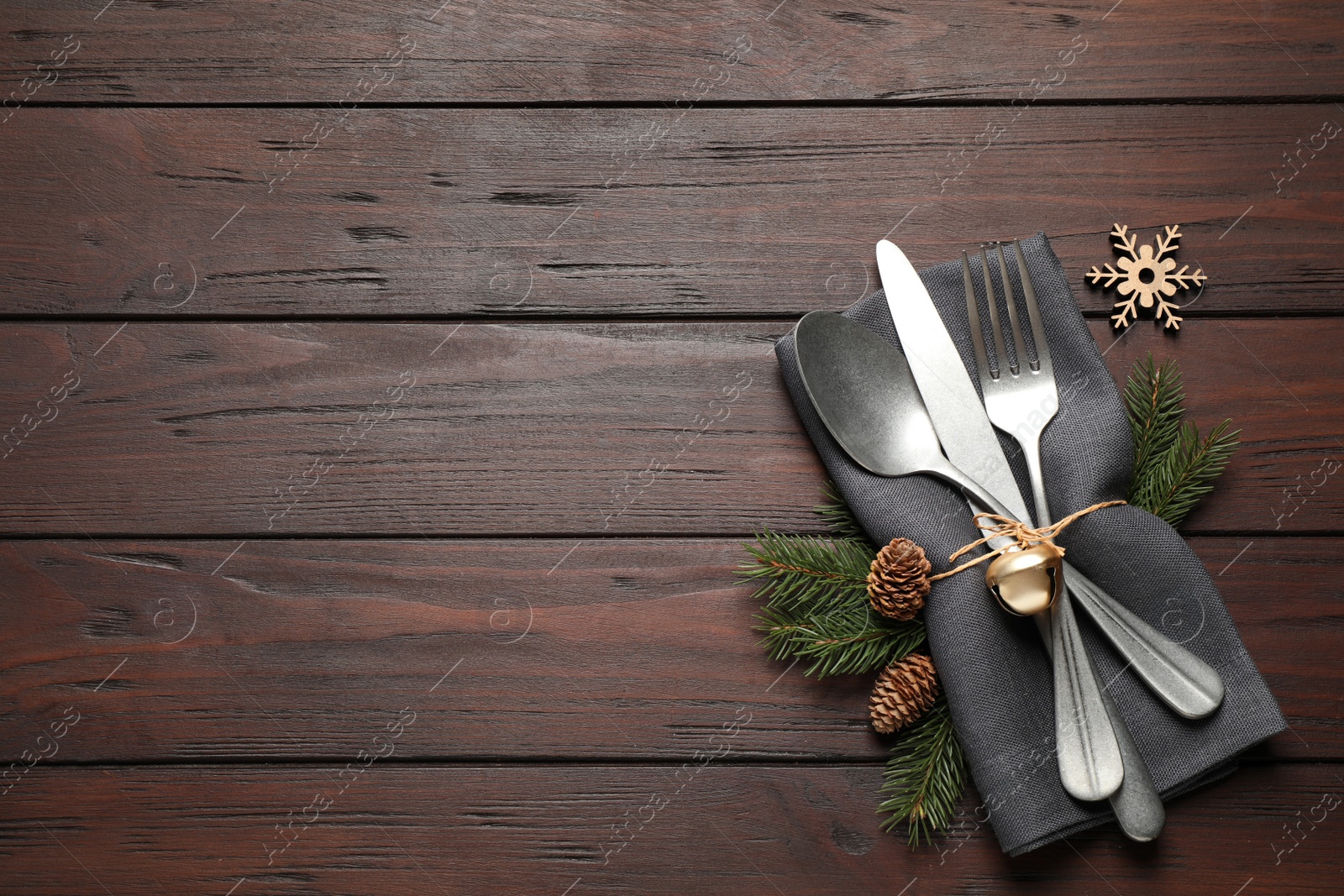 Photo of Cutlery set and festive decor on wooden table, flat lay with space for text. Christmas celebration