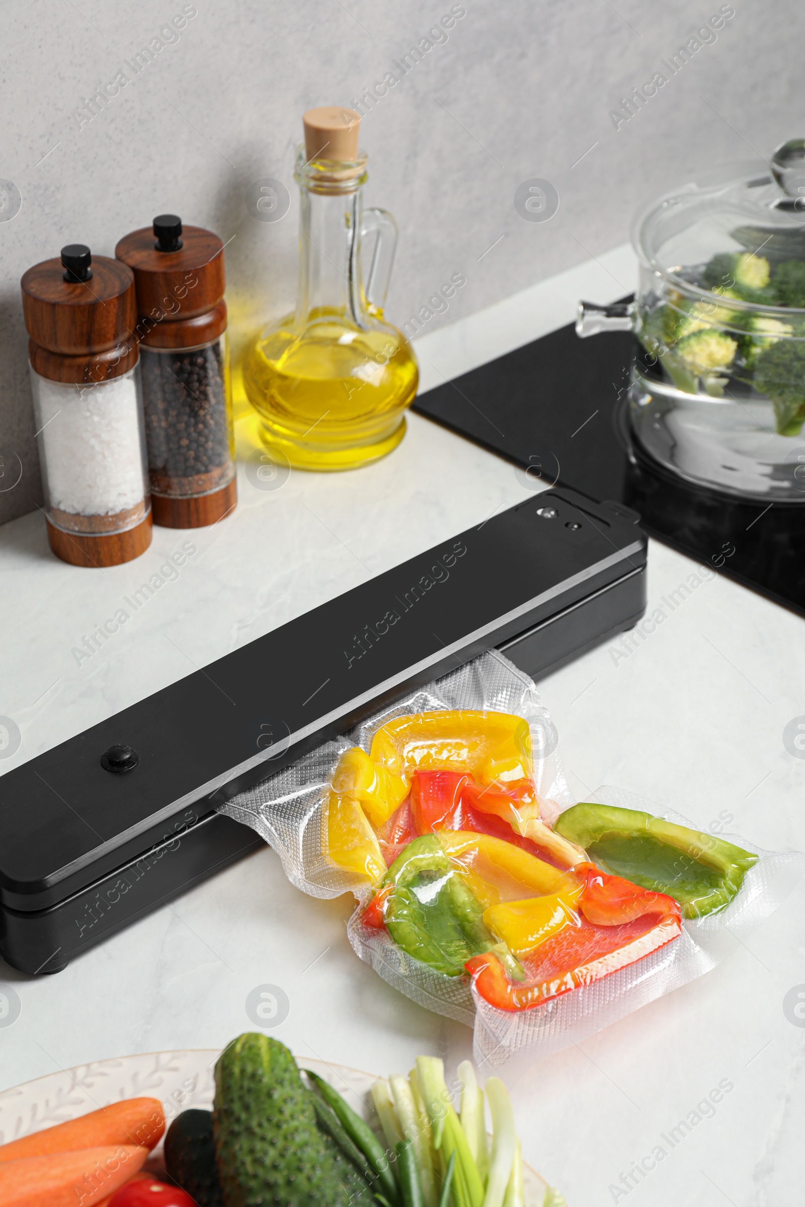 Photo of Sealer for vacuum packing with plastic bag of bell pepper on counter in kitchen