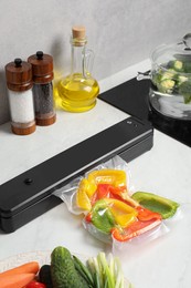 Photo of Sealer for vacuum packing with plastic bagbell pepper on counter in kitchen