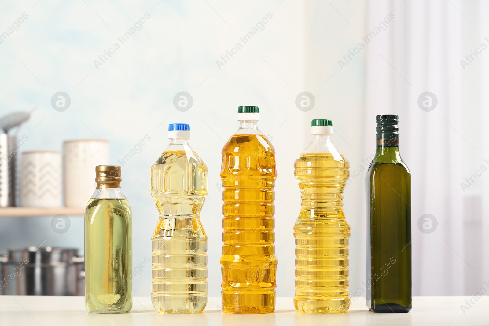 Photo of Bottles of oils on table against blurred background