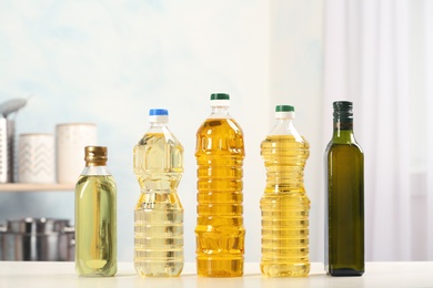 Photo of Bottles of oils on table against blurred background