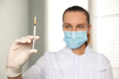 Photo of Doctor with syringe in hospital, focus on hand. Vaccination day