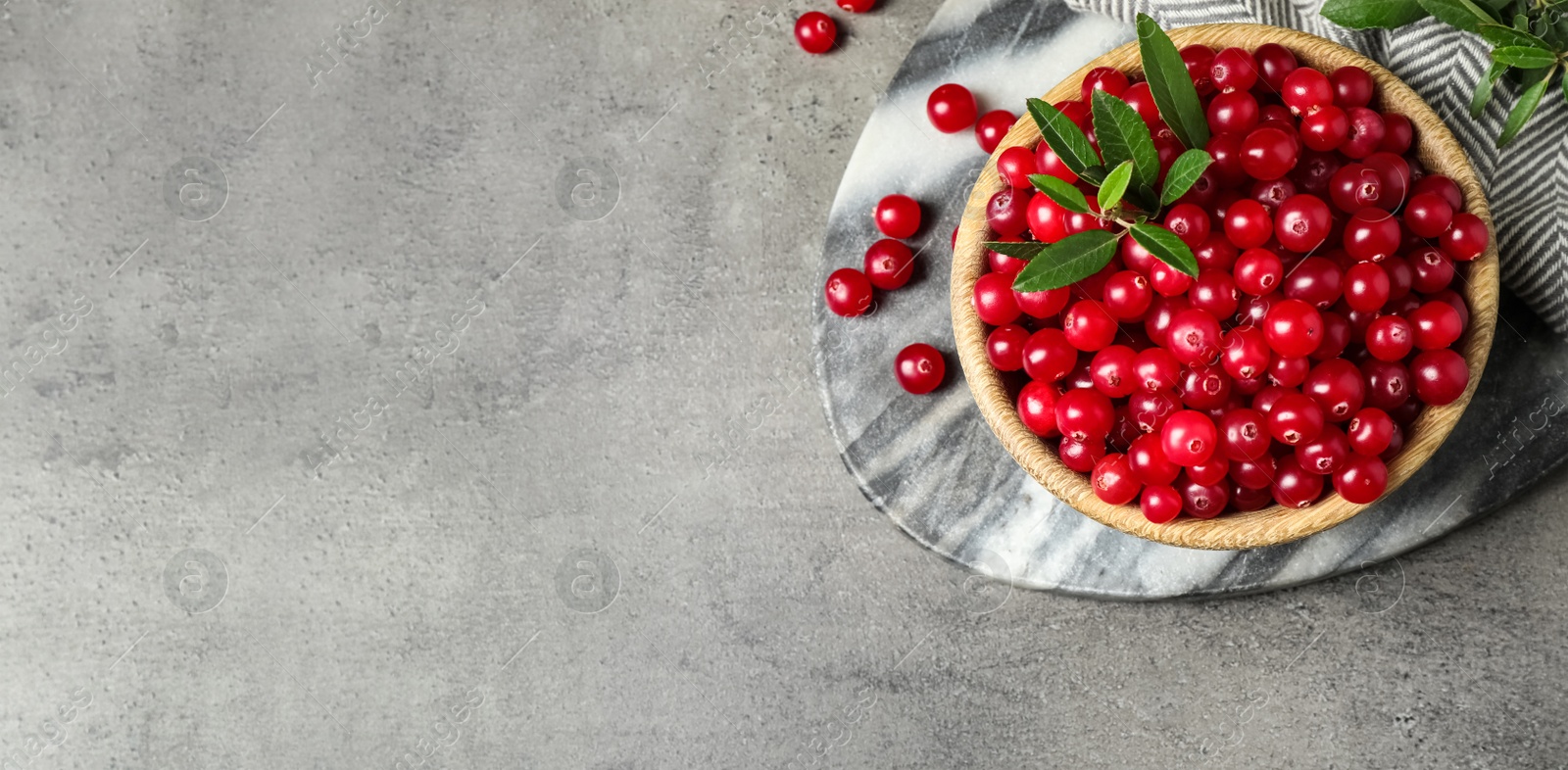 Image of Tasty ripe cranberries on grey table, flat lay. Banner design with space for text