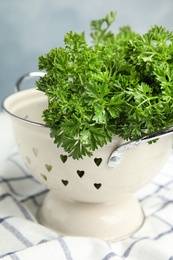 Photo of Colander with fresh green parsley on table, closeup