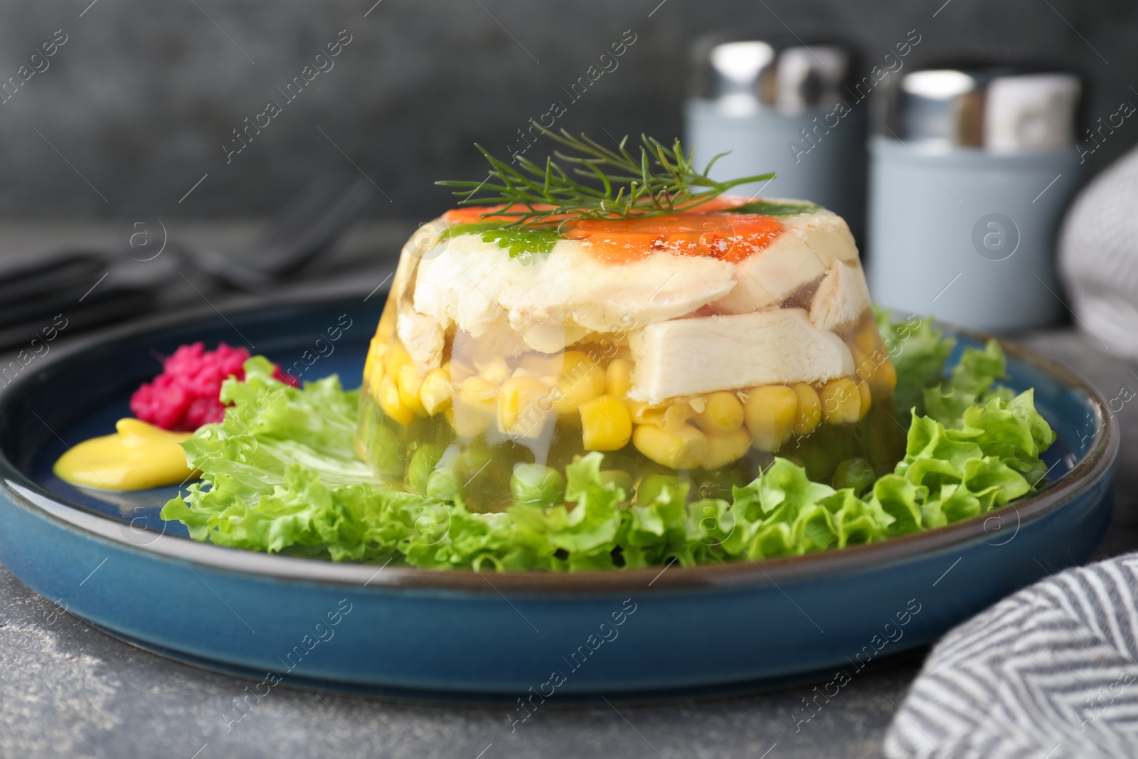 Photo of Delicious chicken aspic served on grey table, closeup