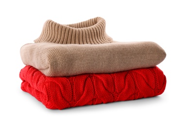 Photo of Stack of different warm sweaters isolated on white