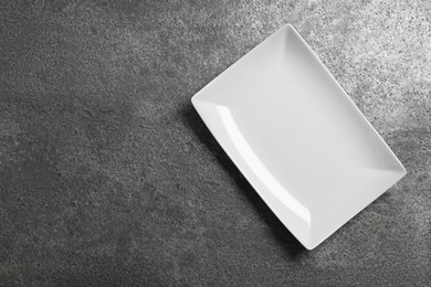 Photo of Empty ceramic plate on grey table, top view. Space for text