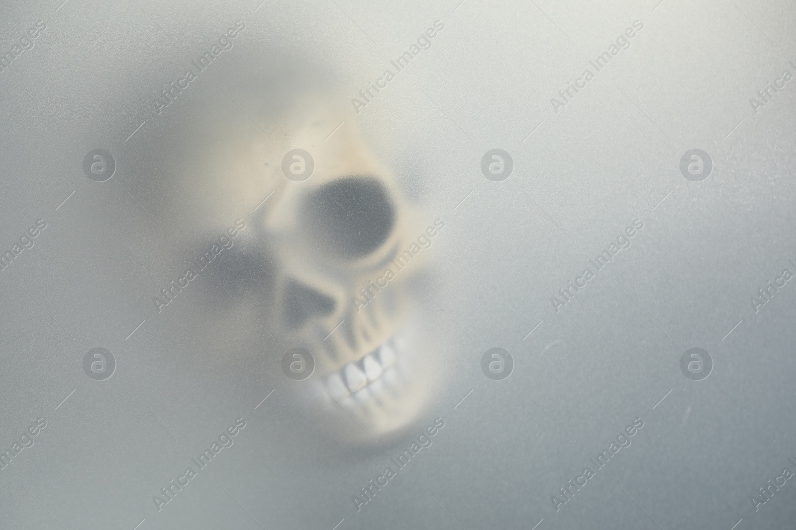 Photo of Silhouette of creepy ghost with skull behind cloth, space for text