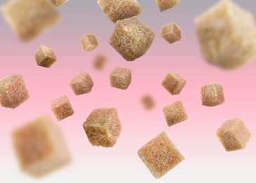 Image of Brown cane sugar cubes falling on color gradient background