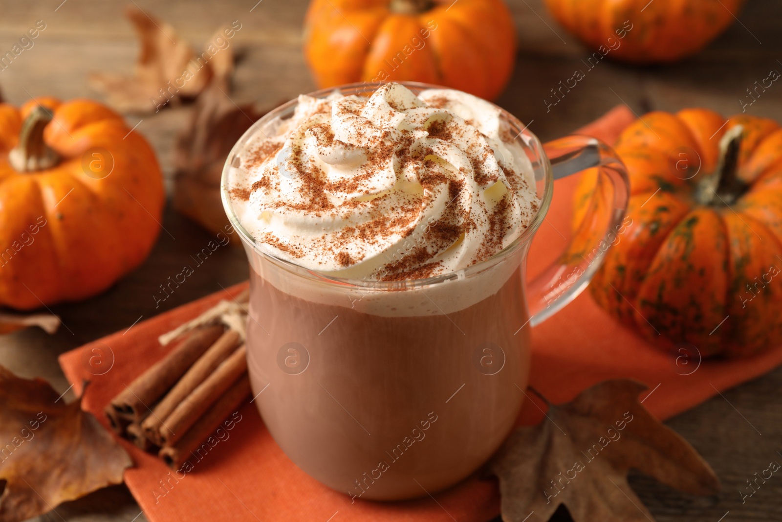 Photo of Delicious pumpkin latte with whipped cream on table, closeup