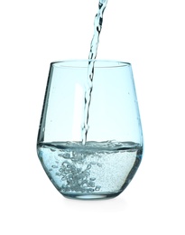 Photo of Pouring water from bottle into glass against blue background. Refreshing drink