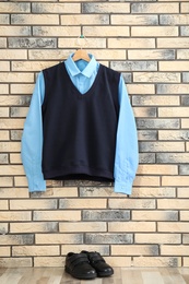 Photo of School uniform for boy hanging on brick wall