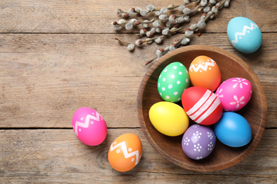 Photo of Flat lay composition with Easter eggs on wooden background. Space for text