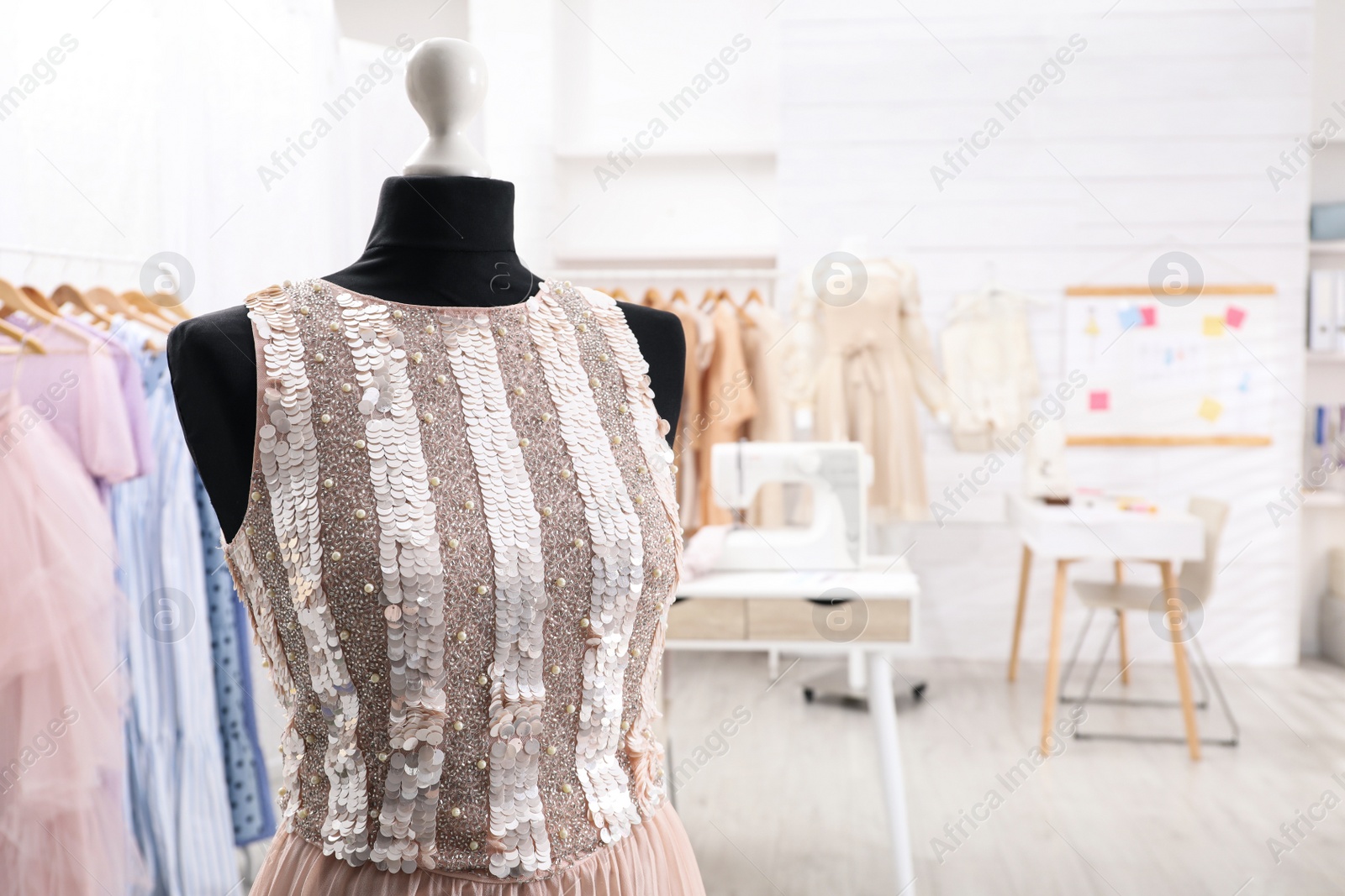 Photo of Mannequin with stylish dress in tailor studio. Space for text
