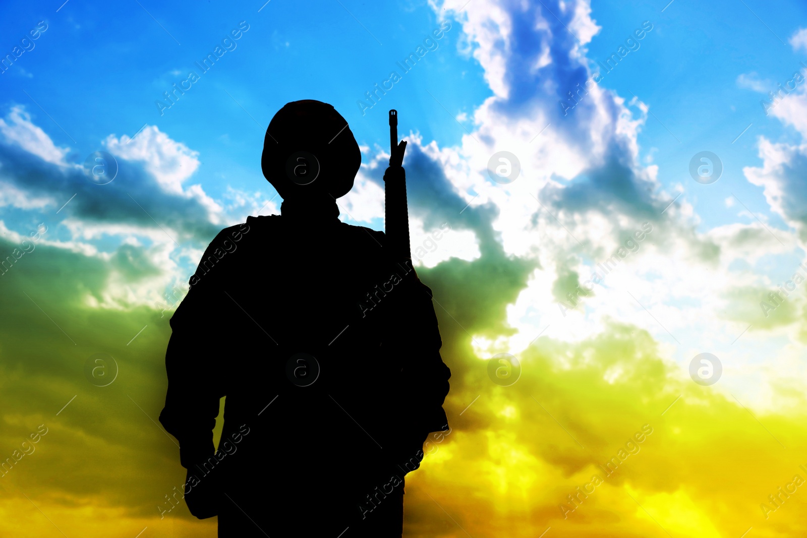 Image of Stop war in Ukraine. Silhouette of armed soldier against sky in Ukrainian flag colors