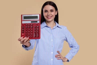 Photo of Smiling accountant against beige background, focus on calculator