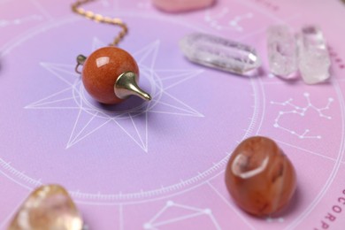 Photo of Astrology prediction. Zodiac wheel, gemstones and pendulum, closeup