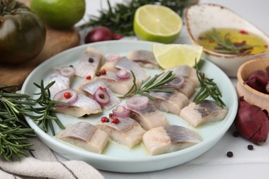 Photo of Tasty marinated fish with rosemary and spices on light table, closeup