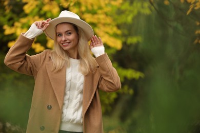 Photo of Portrait of happy woman in autumn park. Space for text