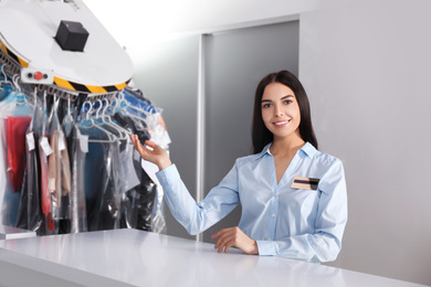 Photo of Female worker near counter at modern dry-cleaner's