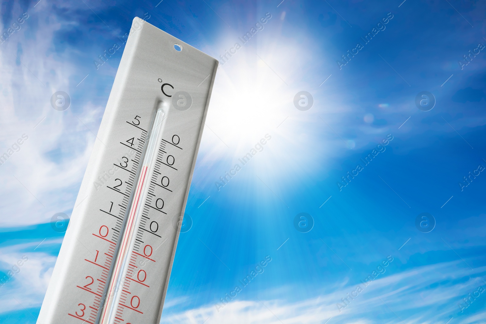 Image of Weather thermometer with high temperature outdoors on hot sunny day. Heat stroke warning