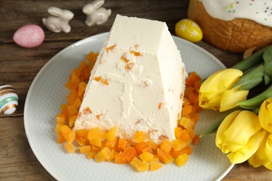 Photo of Traditional cottage cheese Easter paskha with dried apricot on wooden table, closeup