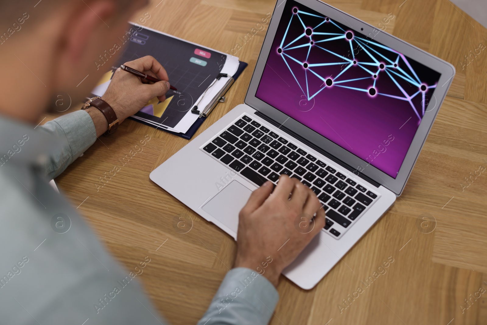 Photo of Businessman working with laptop and graph at table, closeup. Forex trading