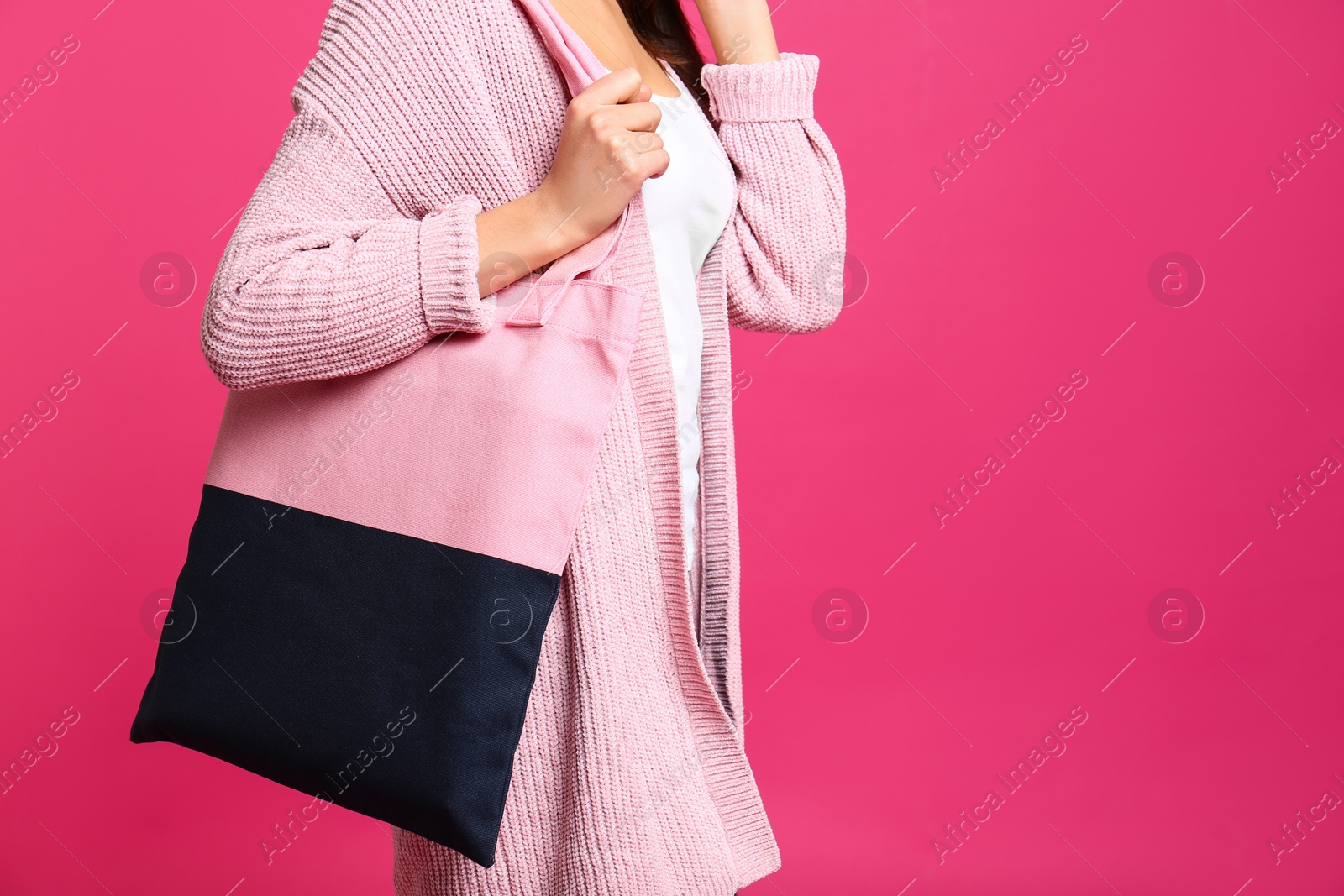 Photo of Young woman with textile bag on pink background, closeup. Space for text