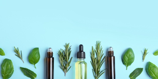 Photo of Flat lay composition with herbal essential oils and space for text on light blue background