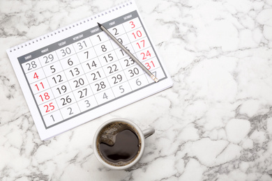 Photo of Flat lay composition with calendar and cup of coffee on white marble table