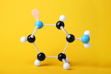 Photo of Structure of molecule on yellow background. Chemical model