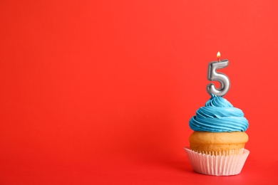 Birthday cupcake with number five candle on red background, space for text