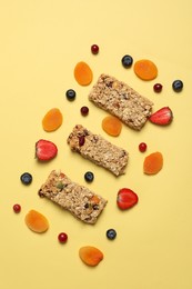 Tasty granola bars and fruits on yellow background, flat lay