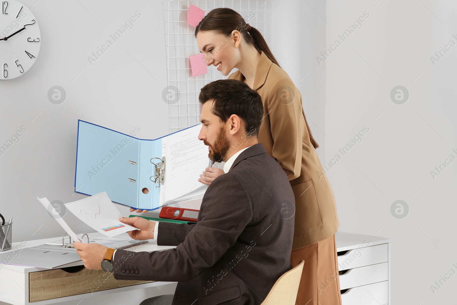 Photo of Businesspeople working together with documents in office