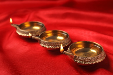 Photo of Diwali diyas or clay lamps on color fabric