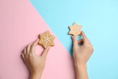 Woman with tasty homemade Christmas cookies on color background