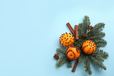 Flat lay composition with pomander balls made of fresh tangerines on light blue background. Space for text