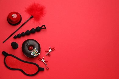 Photo of Flat lay composition with sex toys on red background. Space for text