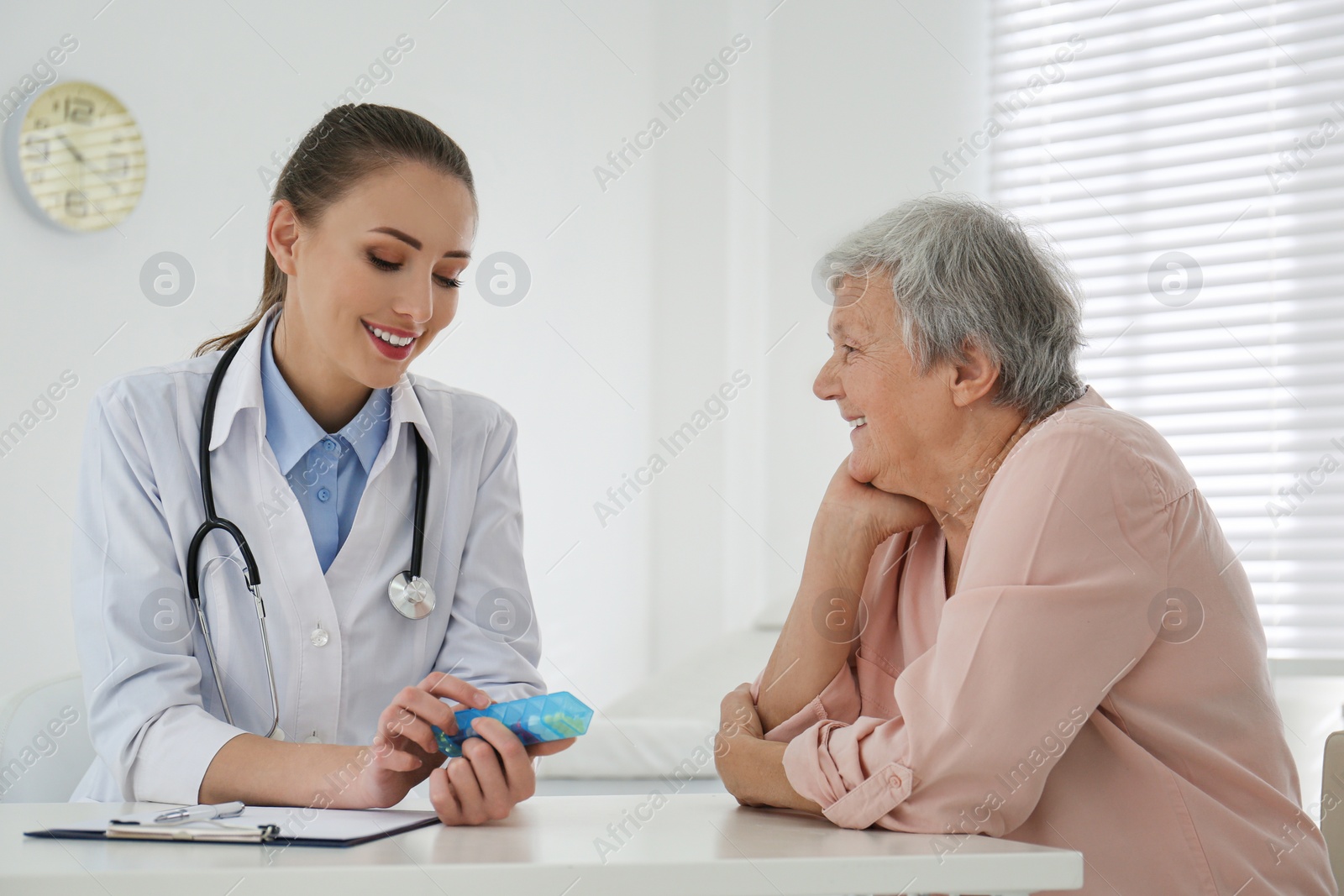 Photo of Doctor giving pills to senior patient in office