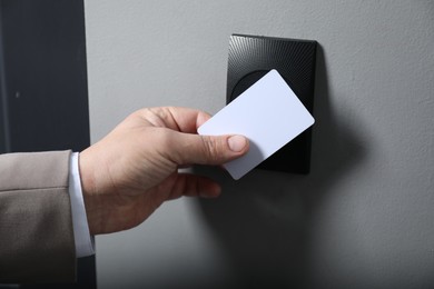 Photo of Man opening magnetic door lock with key card, closeup. Home security